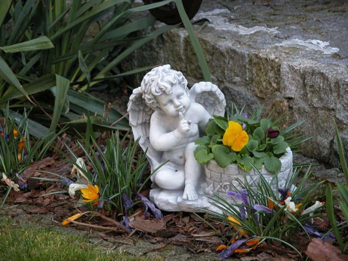 Небольшая гипсовая фигурка ангела в саду