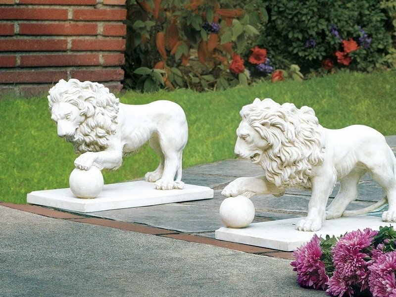 Белые фигуры гипсовых львов для украшения участка